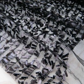Au mètre, tissu avec mini languettes sequins accrochées au fil polyester noir, effet pailleté et brillant en 145cm n°11003